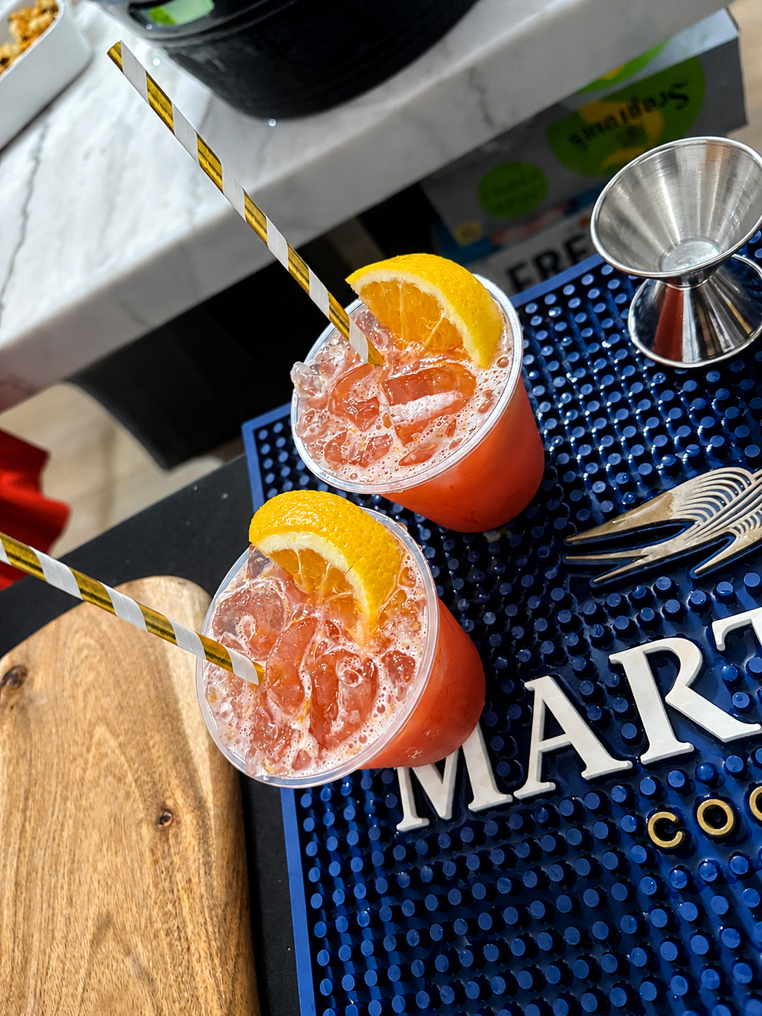 Two refreshing pink cocktails with orange garnishes